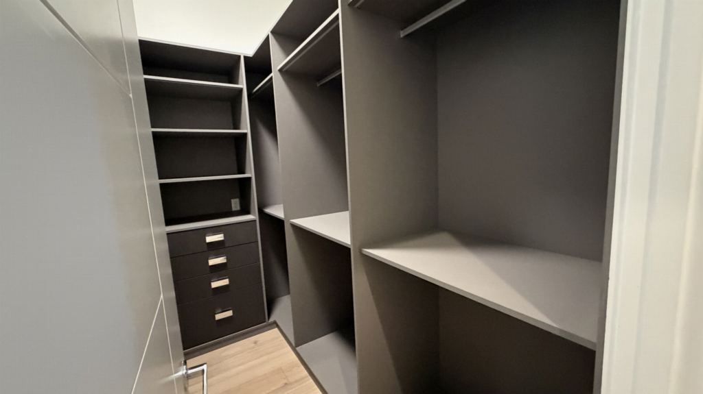 Walk-in closet in graphite lacquer with integrated handle-free drawers and open display shelving