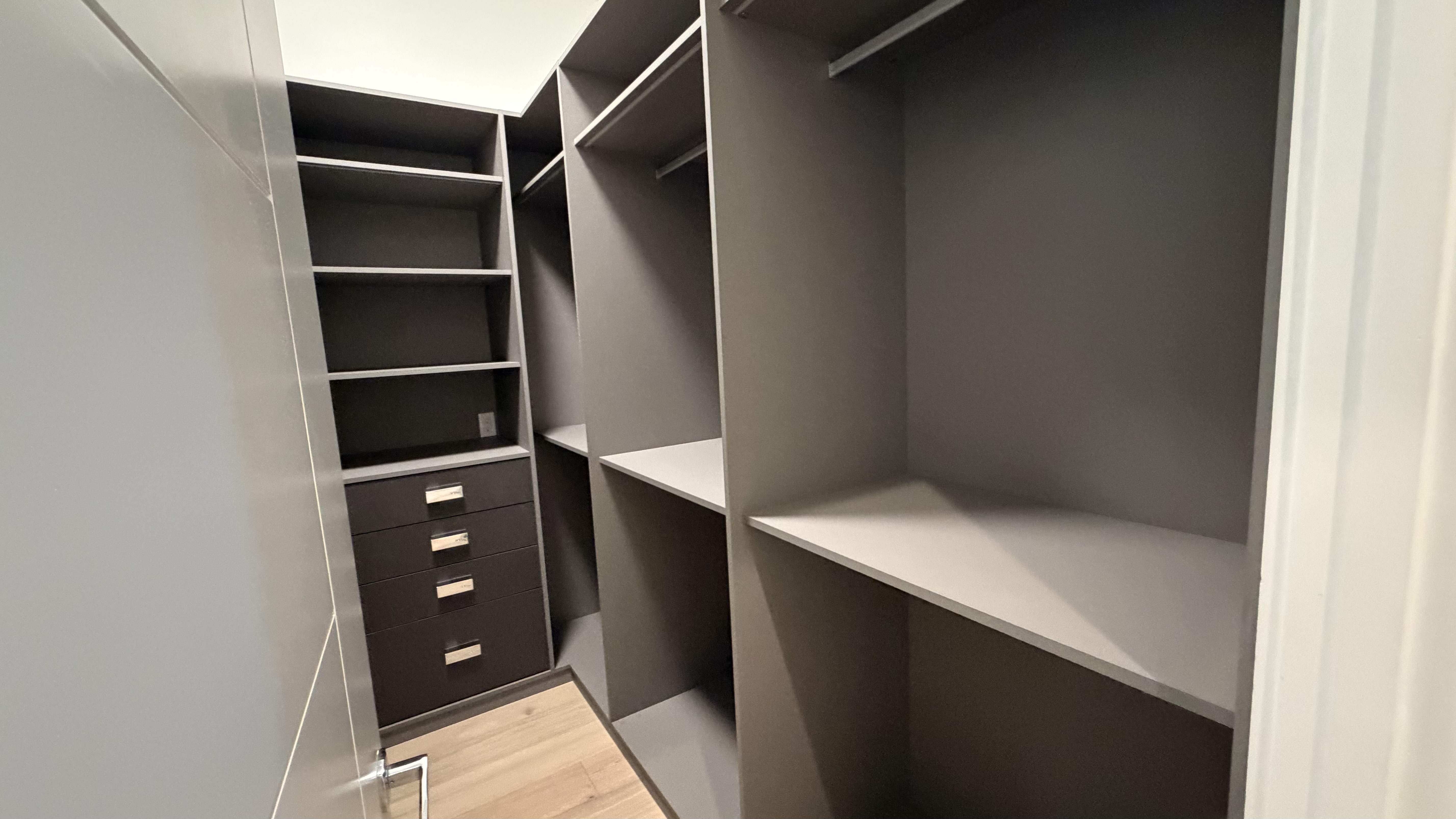 Walk-in closet in graphite lacquer with integrated handle-free drawers and open display shelving