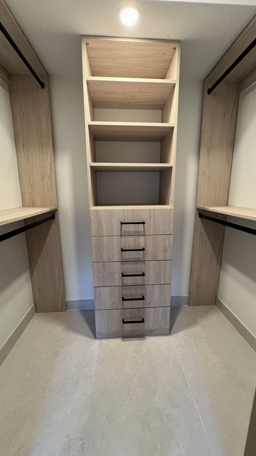 Custom oak walk-in closet suite with full-height cabinetry and integrated lighting