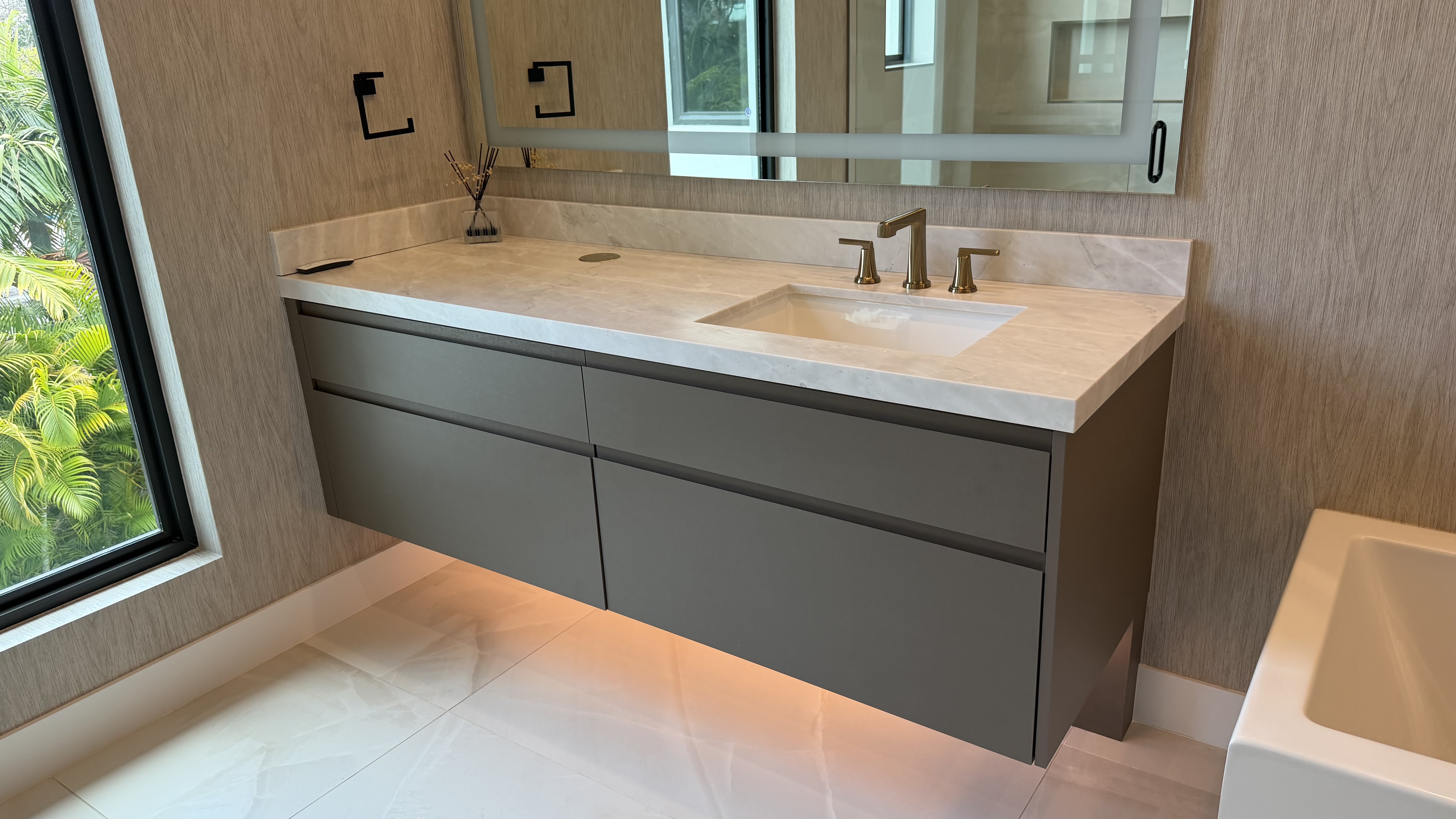 Floating marble vanity with vessel sink and full-height mirror panel