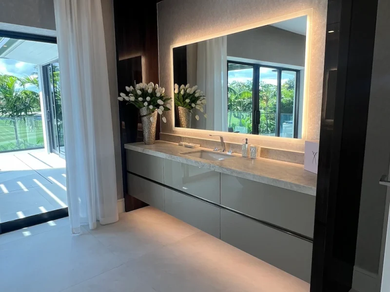 uxury modern bathroom with floating double vanity, backlit LED mirror, marble countertop, and white tulips